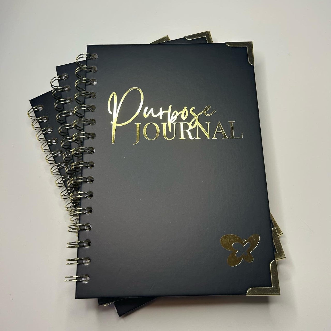 Midnight Black front hardcover with a smooth finish features the word "Purpose Journal" stamped in gold. 